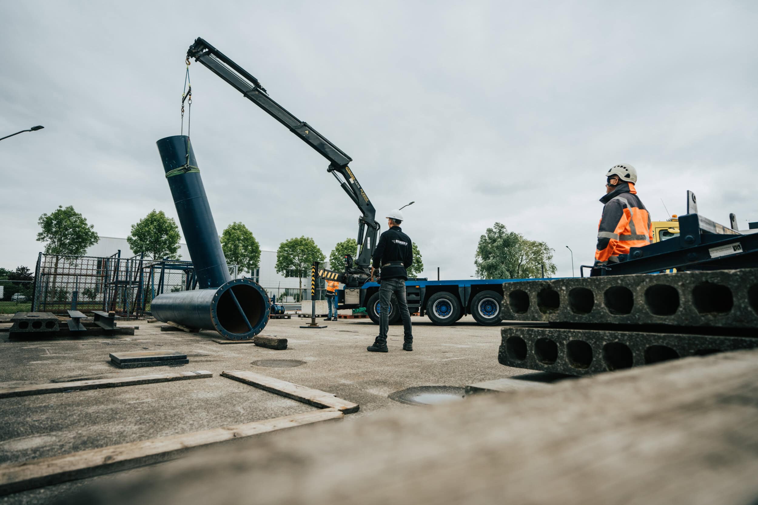 Veilig hijsen op bouwplaats met hijskraan tijdens montage van constructie
